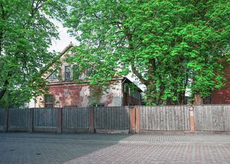Old house with a wooden fence in Ventspils of Latvia
