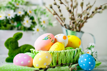 Fototapeta na wymiar Happy Easter. Congratulatory easter background. Easter eggs and flowers. Background with copy space. Selective focus.