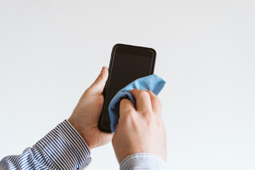 close up view of a man cleaning mobile phone with disinfectant. Hygiene and coronavirus covid-19 concept