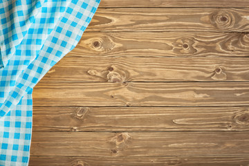 Blue checkered tablecloth on wooden table. Background with copy space. Horizontal. Top view.