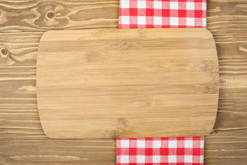 Red checkered tablecloth and wooden spoon for cooking and baking. Background with copy space. Horizontal.