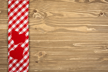 Obraz premium Red checkered tablecloth and wooden spoon for cooking and baking. Background with copy space. Horizontal.