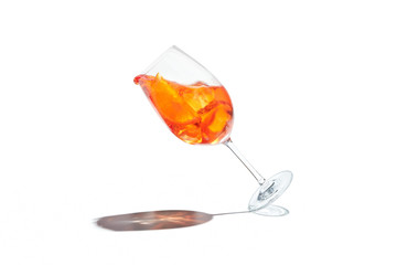 Balancing wineglass with Aperol Spritz cocktail