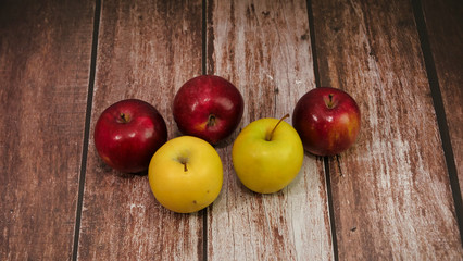 Des pommes sur une table en bois brune et des lattes en bois teinture brunne