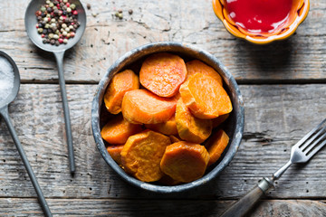 Delicious fried sweet potatoes on the wooden background.