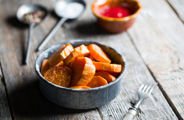 Delicious fried sweet potatoes on the wooden background.
