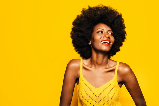 Happy Afro Woman posing over yellow background