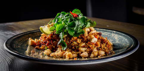 Fried rice with chicken and vegetables in plate on wooden table background