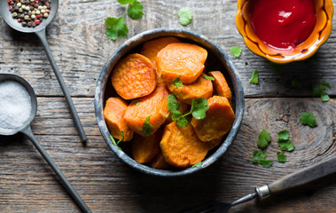 Delicious fried sweet potatoes on the wooden background.
