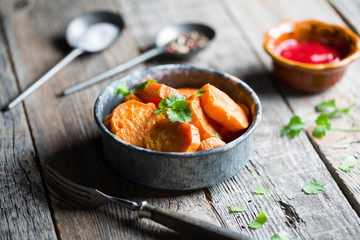 Delicious fried sweet potatoes on the wooden background.