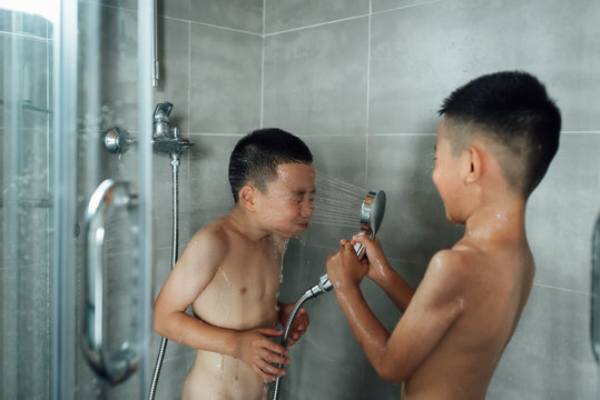 Two boys are taking a shower together