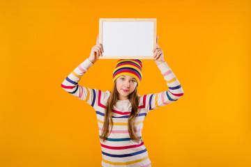 A happy girl teenager holds in his hands an empty drawing board. space for text