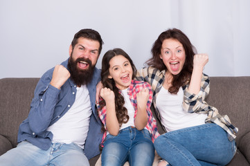 Togetherness is our power. Weekend finally. Little girl relaxing with parents. Stay at home. Family sit on couch. Happy father mother and daughter. Quarantine and isolation concept. Smiling family