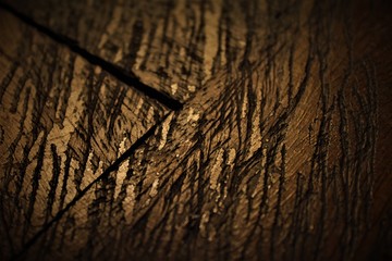 Fondo de textura de madera oscura, antigua y agrietada con destellos de luz dorada