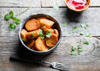 Delicious fried sweet potatoes on the wooden background.