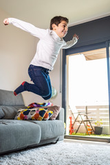 Funny kid jumping off the couch