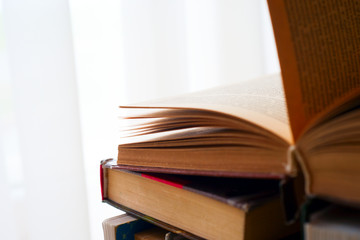 Open book, hardback books on bright colorful background.