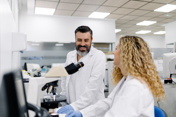Coworkers chatting in the laboratory. They are having break. Medical concept