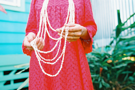 tahiti girl in red dress with white shell leis