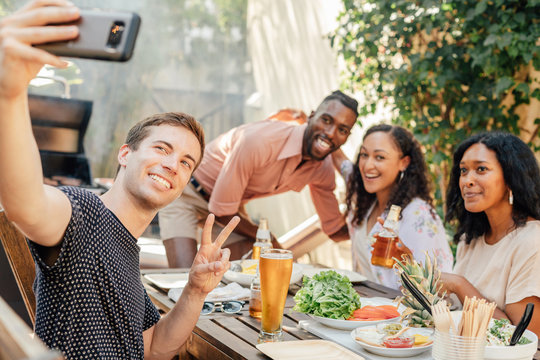 Man Takes Selfie at BBQ with Friend