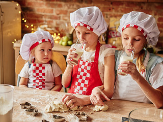 children drinking milk in kitchen. Cooking girls
