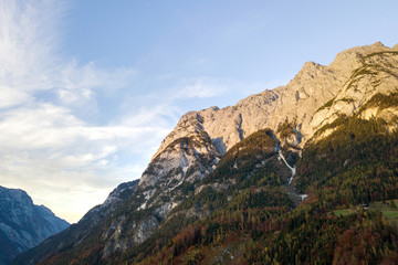 Aerial view of majestic european Alps mountains covered in evergreen pine forest in autumn.