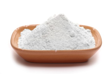 Pile of wheat flour in clay pot isolated on white background