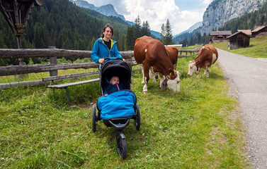 Mother walking in an alpine terrain using a jogging stroller