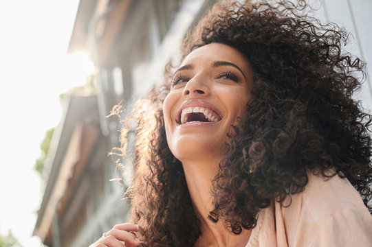 Happy curly hair young woman. - Powered by Adobe