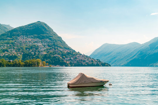 Boat in Lugano lake by Lugano city with impressive Alps mountains