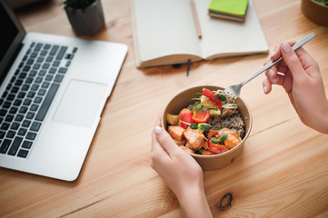 A woman has lunch and works at home. Top view. Space for text in the smartphone