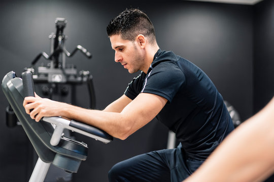 young man at the gym on a bicycle