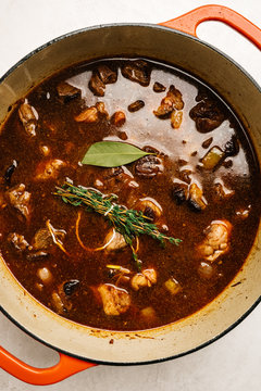 Hearty beef stew with herbs in a Dutch oven