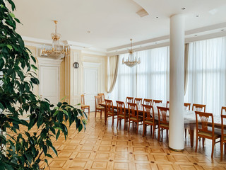 the interior of a white room with a large dining table and a green plant