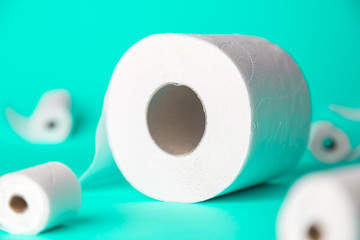 Big and small toilet papers on turquoise background. New Corona virus infection(novel corona virus disease) background. Pandemic panic concept.