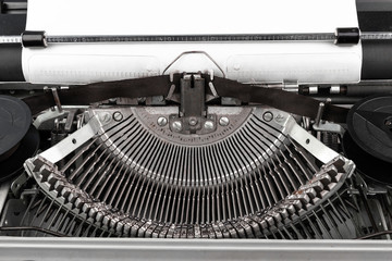 Close-up photo of vintage typewriter with empty paper sheet. Place for copy space for your text.