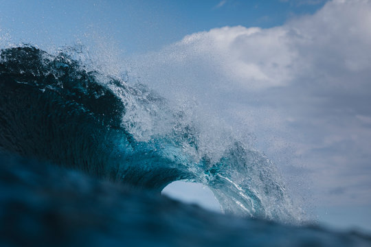 A powerful wave breaks under a cloudy sky in Gran Canaria, Spain.
