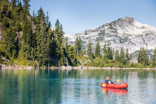 Retired woman enjoying a paddle on remote mountain lake.