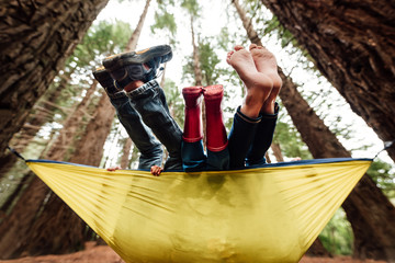 Feet of three children in a yellow hammock