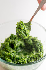 pesto sauce in a jar take a spoon. Close shot