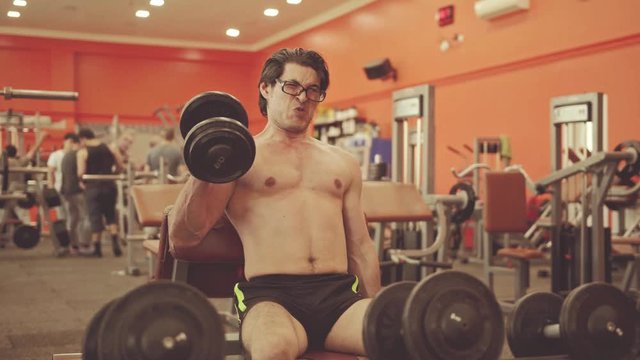 Handsome Young Man Doing Exercises biseps In The Gym