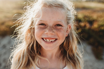 Close up Portrait of young school age girl with freckles smiling