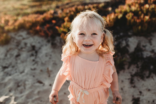 Portrait of young toddler girl with pigtails smiling on beach