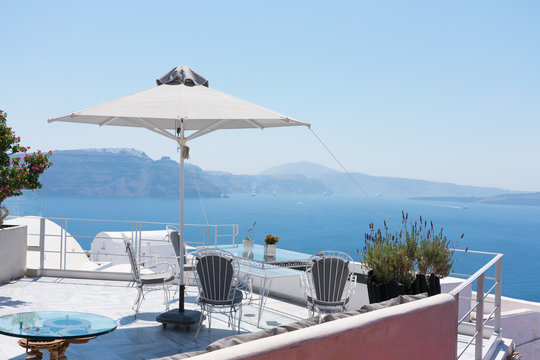 Terrace with nobody in the greek island of Satorini with the best landscape of the Aegean sea with ships and the Caldera of the volcano with the main town of Fira at the top of the cliff. Hor