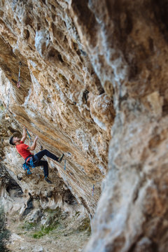 Climber begining a hard sport climbing route in a cave.