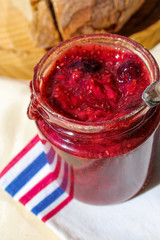 Jam jar close up. Strawberry and blueberry homemade jam in a table with rustic bread. Healthy breakfast table. 