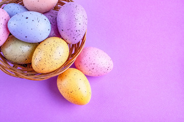 Naklejka na ściany i meble Easter multi-colored eggs on a lilac background