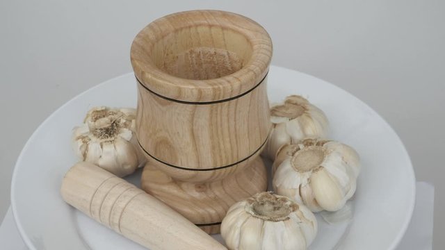 garlic grains on wooden background, close up, wood garlic crusher and garlic,