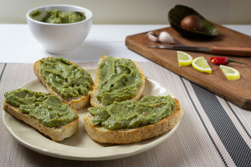 Guacamole sandwiches with ingredients on a wooden background. Healthy eating Vegetarian food.