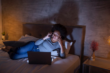 Fototapeta premium Woman lying in bed having a phone conversation